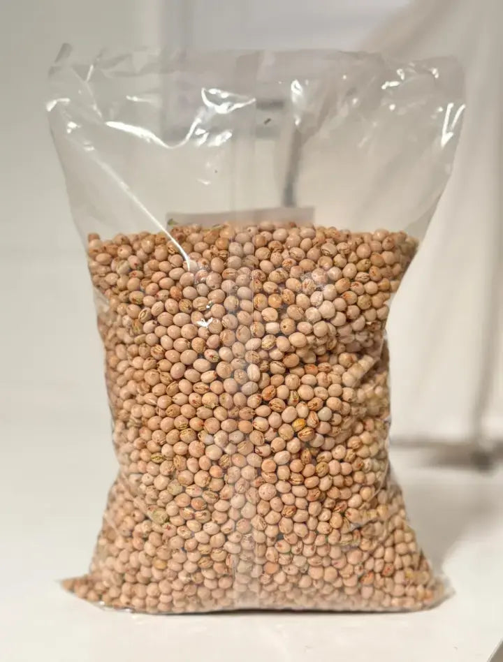 Clear plastic bag filled with dried chickpeas on a white background